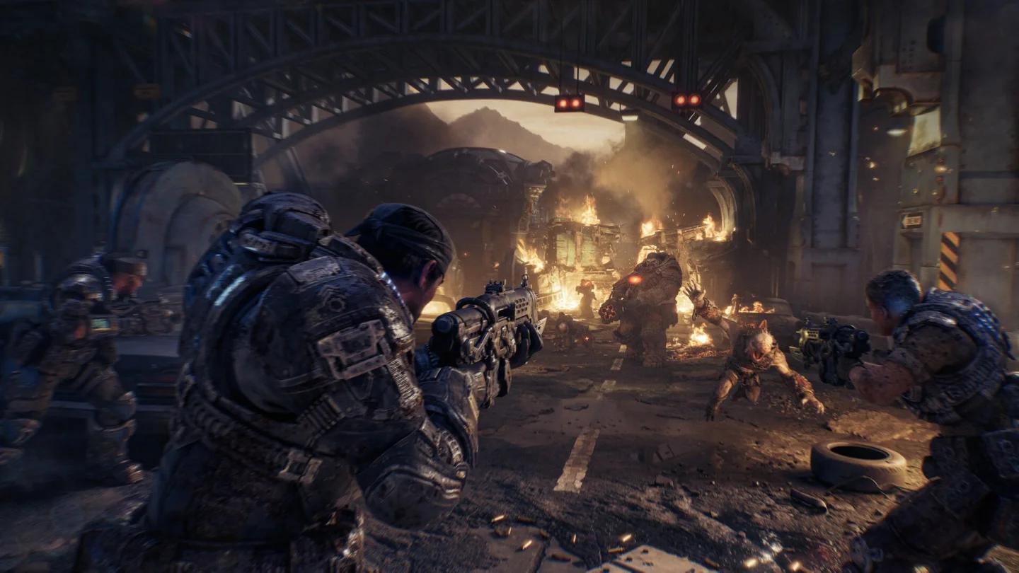 Gears of War: E-Day oyun içi çatışma sahnesi, yanan köprü altında düşmanlar